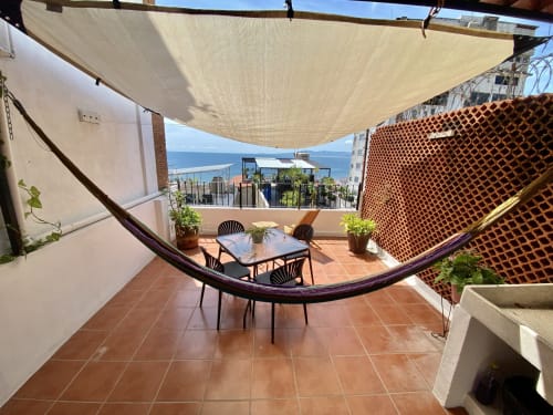 Anita Ocean View apartment balcony in Puerto Vallarta with sea views, hammock, dining table, and shade sail