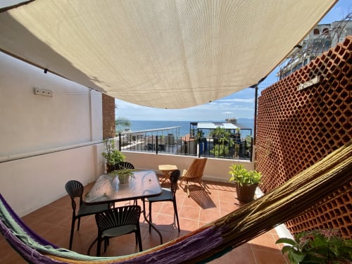 Burbuja apartment balcony with sea view, dining table, shade sail, and ocean vista in Puerto Vallarta