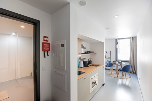 Moderno estúdio no Benefit Collection Porto com kitchenette, área de refeições e espaço de estar em azul