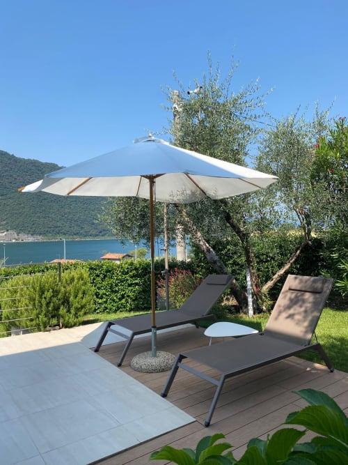 Verdolivo B&B terrace with loungers, umbrella, and lake view in Sale Marasino, Italy