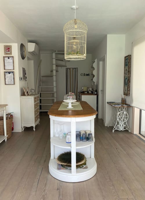 Verdolivo BnB interior showing round white island with wood top, decorative birdcage pendant light, Sale Marasino