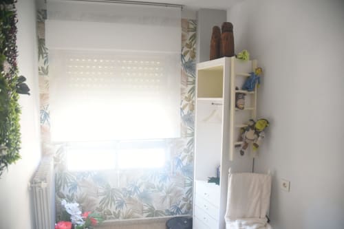 Bright bathroom in Benavente tourist apartment with floral-patterned tile, white vanity, and decorative shelving