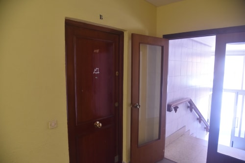 Pasillo del apartamento turístico de Benavente con paredes amarillas, puertas oscuras y acceso a espacios luminosos