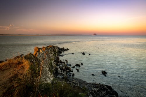 Falaises rocheuses côtières au coucher de soleil surplombant la baie près du Petit Lustucru, Avranches, France