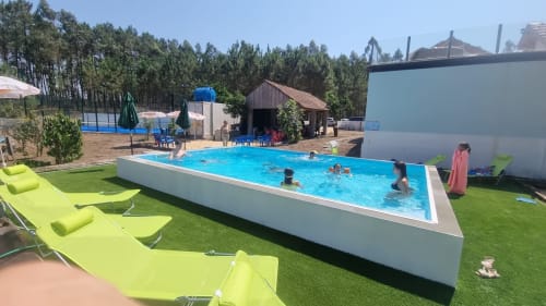 Outdoor swimming pool with bright lime green loungers at Charm Discovery Experiences in Leiria, Portugal