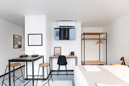 Estudio moderno en Oporto con cocineta, comedor, escritorio, TV y armario en diseño escandinavo minimalista