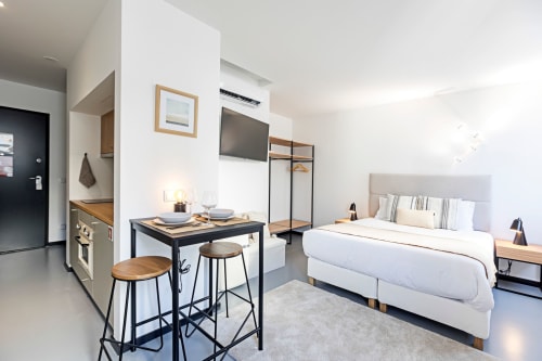 Modern studio apartment at Benefit Collection Porto featuring bed, kitchenette, dining area, and TV