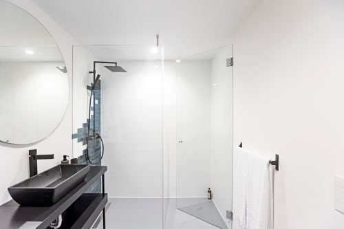 Modern bathroom in Benefit Collection hotel Porto with black vessel sink, rainfall showerhead, glass enclosure, and white