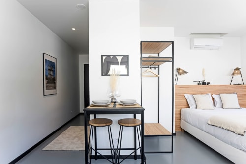 Estudio moderno en Benefit Collection Porto con mesa de comedor, cama de marco de madera, cocina americana y decoración contemporánea
