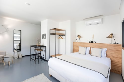 Modern studio apartment at Benefit Collection Porto with wooden bed, kitchenette, and contemporary furnishings