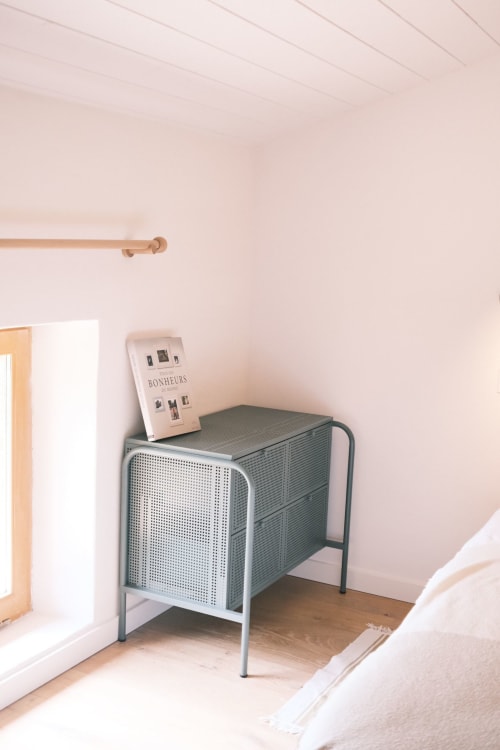 Commode verte moderne dans la chambre Coton de la Maison Monsieur Léger à Montaut, avec livre de décoration et tringle en bois