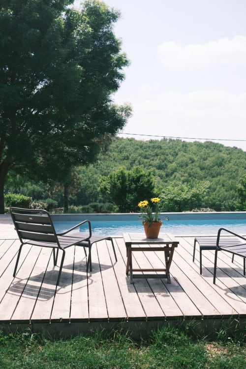Terrasse en bois avec chaises longues donnant sur la piscine privée et les collines boisées de la villa Maison Monsieur Léger à Montaut, France