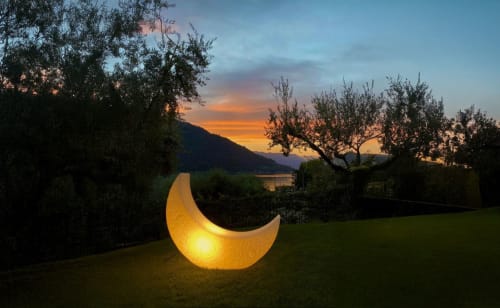 Glowing crescent moon sculpture in garden at Verdolivo B&B, Sale Marasino, with sunset and lake view