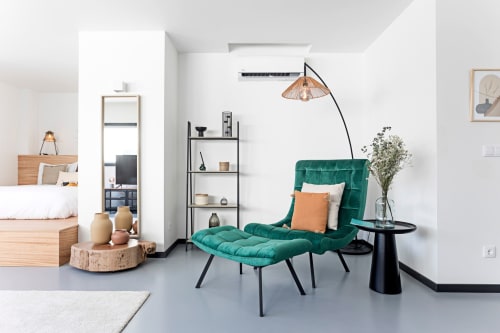 Studio Superior Benefit Collection en Porto: estudio moderno con asientos de terciopelo turquesa, lámpara de arco, muebles de madera y blanco