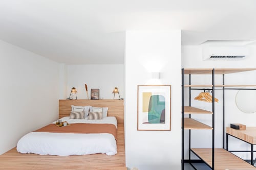 Estudio superior moderno de Benefit Collection Porto con cama de madera, ropa blanca, decoración minimalista y unidad de almacenamiento