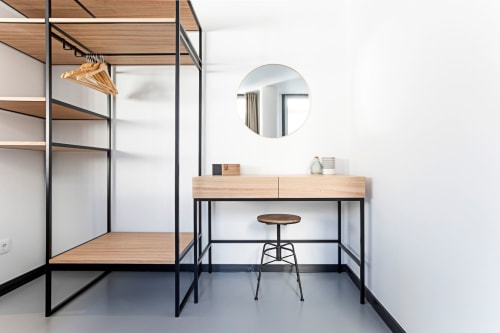 Dormitorio estudio moderno en Benefit Collection Porto con cama dosel de madera, tocador, espejo redondo, estilo industrial