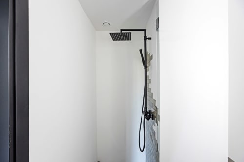 Área de ducha moderna con alcachofa de lluvia en estudio compacto del hotel Benefit Collection, Oporto