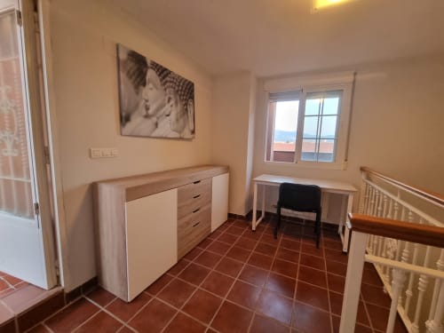 Bedroom with wooden storage cabinet, desk, chair, and window with mountain views at CTH Granada cottage in Armilla