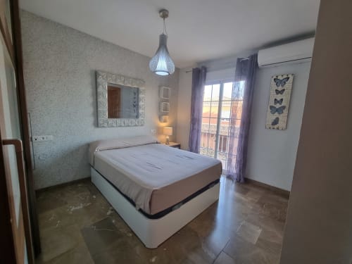 Modern bedroom in Boabdil House cottage at CTH Granada, Armilla, with queen bed, balcony access, mountain views, and