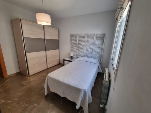 Modern bedroom in Boabdil House cottage at CTH Granada with single bed, wooden wardrobe, and mountain views
