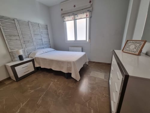 Bright bedroom in Boabdil House cottage, CTH Granada, with single bed, white furniture, marble flooring, and mountain views