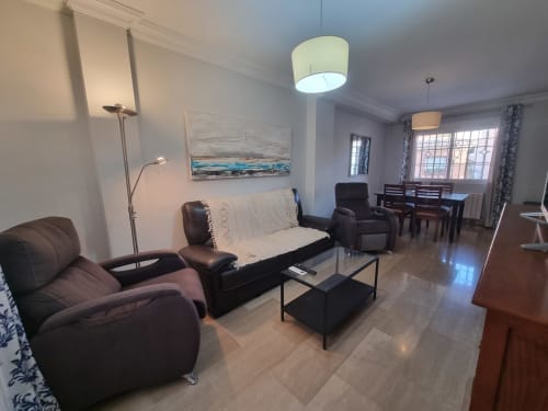 Modern living room in Boabdil House cottage at CTH Granada with leather seating, sofa, flat-screen TV, and mountain views