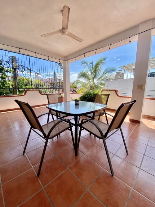 Covered balcony with dining table and chairs at Anita Ocean View apartment in Puerto Vallarta, sea view