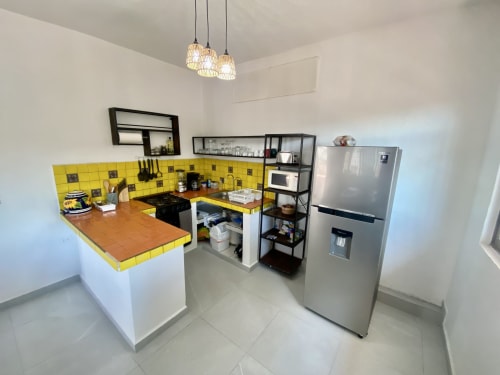 Modern kitchen in Anita Ocean View apartment, Puerto Vallarta with yellow tile backsplash, stainless steel appliances, and