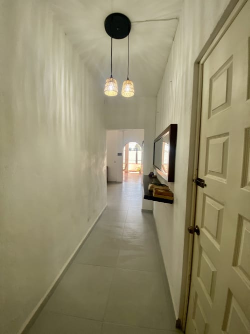Modern hallway at Anita Ocean View apartment in Puerto Vallarta with pendant lighting and open rooms