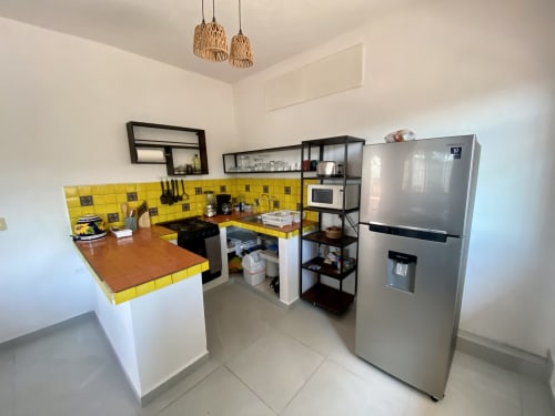 Bright modern kitchen at Anita Ocean View in Puerto Vallarta with yellow tile backsplash, stainless steel appliances and