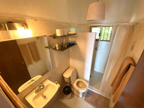 Bright bathroom in Anita Ocean View apartment, Puerto Vallarta with sink, toilet, shower and towel rack