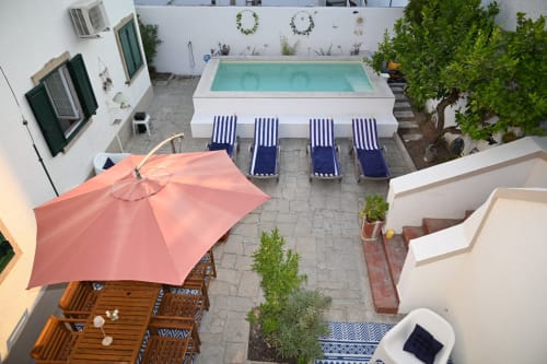 Pátio da Villa Sor com piscina turquesa, espreguiçadeiras, guarda-sol coral e área de refeições em Ponte de Sor, Portugal