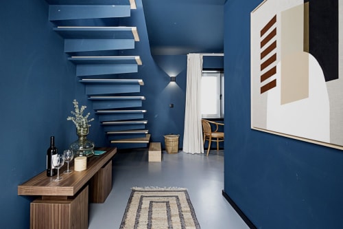 Modern Porto hotel duplex studio with blue walls, wooden shelves, kitchenette, and contemporary furnishings
