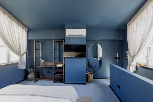 Moderno estúdio duplex no Porto com paredes azuis, cama, kitchenette, banheiro, escrivaninha e ar condicionado