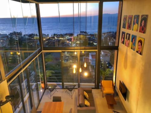 Anita Ocean View hotel suite at dusk with panoramic ocean and mountain views through floor-to-ceiling windows