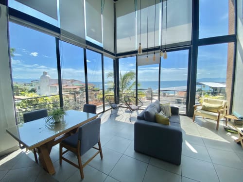 Modern living room at Anita Ocean View hotel in Puerto Vallarta with ocean views, dining table, and contemporary furnishings