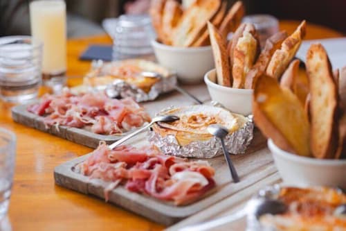 Charcuterie board with cured meats, bread slices, and spreads at Hôtel Manon Marseille breakfast buffet