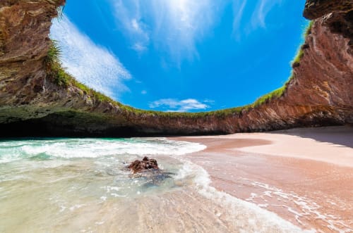 Secluded beach cove with turquoise waters, white sand, and dramatic cliffs at Anita Ocean View, Puerto Vallarta