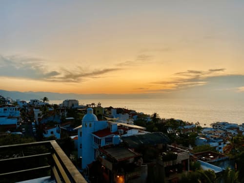 Sunset view over Puerto Vallarta from Anita Ocean View with blue-domed church and coastal town architecture