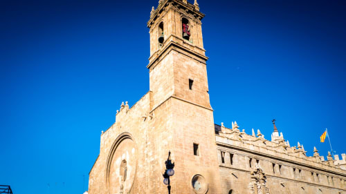 Torre de iglesia histórica de piedra con arquitectura ornamentada en el centro de Benavente bajo cielo azul