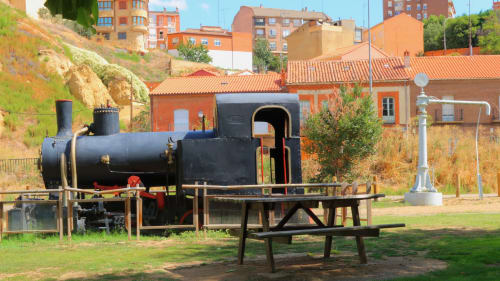 Histórica locomotora de vapor con mesa de picnic en el parque de Benavente, destacando patrimonio local y atracción turística