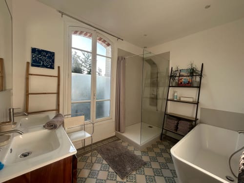 Modern bathroom at Villa Saint-Hilaire, Locavilla Colombes with walk-in shower, dual sinks, and garden view