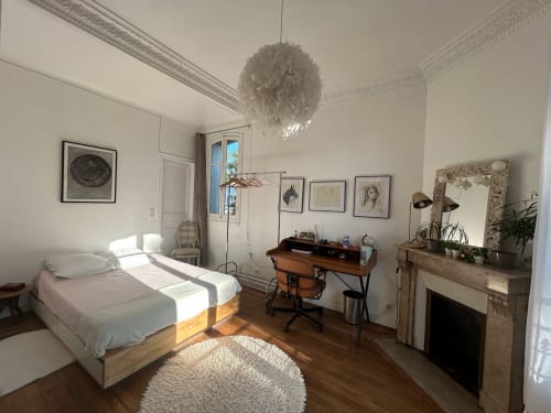Bright bedroom at Locavilla villa in Colombes with bed, desk, fireplace, and garden view