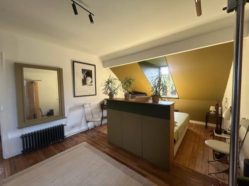 Modern villa suite with wooden floors, dark desk, potted plants, and garden view at Locavilla Colombes