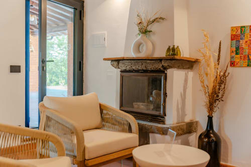 Moderna zona salotto a Tenuta Alela con poltrona intrecciata, camino e vasi decorativi a Figline Valdarno, Italia