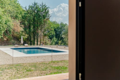 Piscina rettangolare con recinzione in vetro affacciata sul parco boscoso di Tenuta Alela, Figline Valdarno