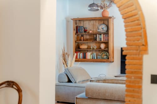 Accogliente zona soggiorno dell'Appartamento Deluxe Tenuta Alela con libreria in legno, divano grigio e arredamento rustico a Figline Valdarno,