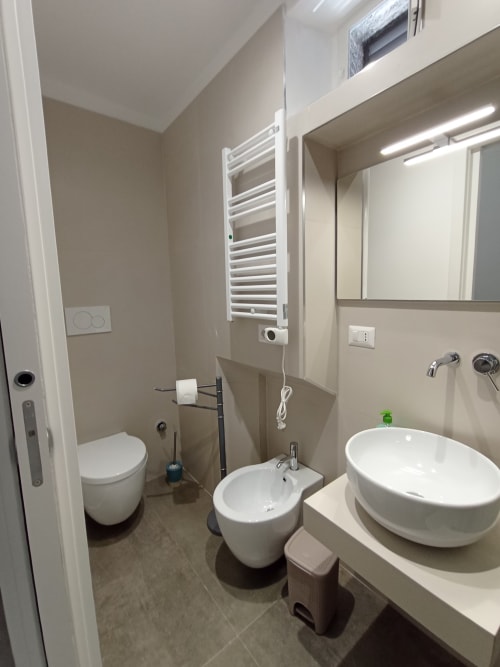 Bagno moderno a Bari Vacation con lavabo cilindrico, bidet, wc e scaldasalviette