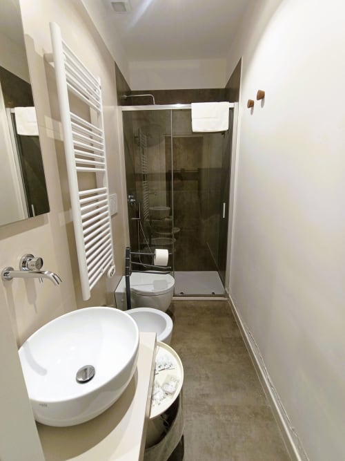 Bagno moderno a Bari Vacation con lavabo bianco, doccia, wc e scaldasalviette
