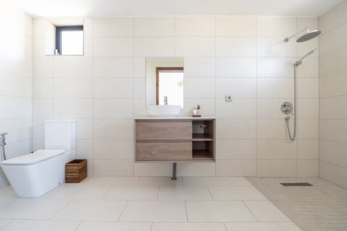Modern bathroom at La Villa Boz villa with floating wood vanity, walk-in shower, and heated flooring in Saint Philbert de